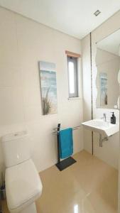 a bathroom with a toilet and a sink at Sunset Street Beach house in Lourinhã