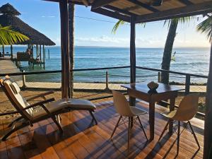 a patio with a table and chairs and the ocean at Casa Cayuco Eco-Adventure Lodge in Bocas del Toro