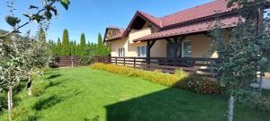 uma casa com um jardim de relva ao lado de um edifício em Carpen View Residence em Săcele