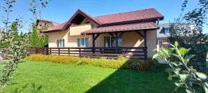 a house with a green lawn in front of it at Carpen View Residence in Săcele