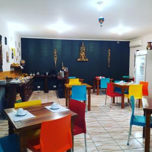 a dining room with tables and colorful chairs at Pousada Estrela Mare in São Sebastião