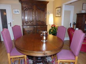 une salle à manger avec une table en bois et des chaises violettes dans l'établissement Résidence Saint-Nicolas Granville, à Granville