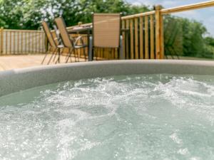 a hot tub filled with water on a patio at Hill Crest Lodge 2 in Hemswell