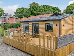 a wooden cabin with a wooden fence at Hill Crest Lodge 2 in Hemswell