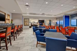 ein Restaurant mit Stühlen und Tischen sowie eine Bar in der Unterkunft Holiday Inn Express Hotel & Suites Virginia Beach Oceanfront, an IHG Hotel in Virginia Beach