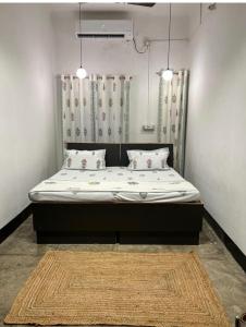 a bed in a room with two pillows and a rug at Wanderlust Hostel & Home Stay in Varanasi