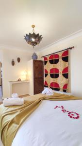 a bedroom with a large white bed with a chandelier at RIAD DAR En-Nawat in Marrakech