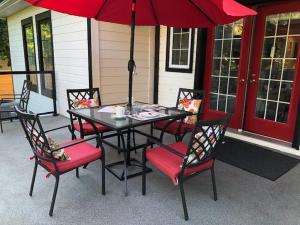 a black table and chairs with a red umbrella at Casa Blanca Boutique Bed & Breakfast in Niagara on the Lake