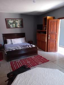 a bedroom with a bed and a dresser and a rug at PalmTree A/2 in El Jadida