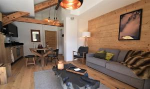 una sala de estar con un sofá y una mesa en VAUJANYLOCATIONS - L'Etendard, en Vaujany