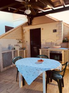 une cuisine avec une table, des chaises et un chiffon bleu dans l'établissement 200 m from the beach - WiFi - Air Conditioning, à San Pietro in Bevagna