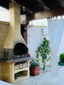 - un four à pizza extérieur dans une terrasse avec rideau dans l'établissement 200 m from the beach - WiFi - Air Conditioning, à San Pietro in Bevagna