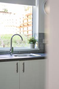 a kitchen counter with a sink and a window at Fully Refurbished North Belfast Home in Belfast