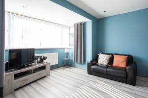 a living room with a couch and a flat screen tv at Fully Refurbished North Belfast Home in Belfast
