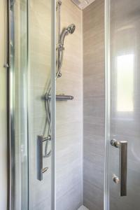 a shower with a glass door in a bathroom at Fully Refurbished North Belfast Home in Belfast