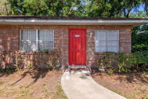 a brick house with a red door and a sidewalk at Fifties Flat MidCentury flat in heart of Brandon in Brandon