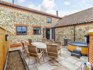 a patio with a table and chairs and a grill at Kestrel Barn-uk31353 in Swaffham