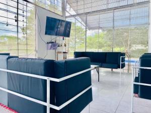 a waiting room with blue chairs and a tv at Finca La Felicidad in Tocaima