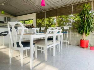 トカイマにあるFinca La Felicidadの白いダイニングテーブルと椅子付きのキッチン