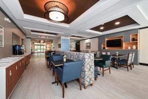 un comedor con mesas y sillas en un restaurante en Holiday Inn Express Charlotte Southeast - Matthews, an IHG Hotel en Charlotte