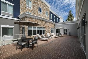 a patio with chairs and a table and an umbrella at Holiday Inn Express Charlotte Southeast - Matthews, an IHG Hotel in Charlotte