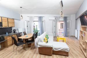uma pequena sala de estar com uma mesa e um sofá em MATILDA Central Apartment em Egina