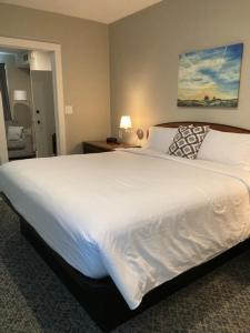 Country Squire Inn and Suites في New Holland: سرير أبيض كبير في غرفة الفندق