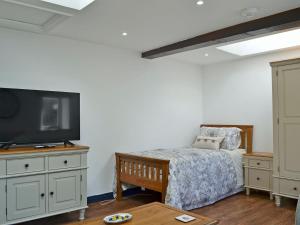 a bedroom with a bed and a flat screen tv at The Dairy - Uk30867 in St Bees