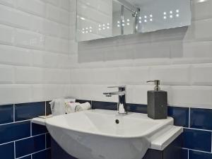 ein weißes Waschbecken in einem blau-weißen Badezimmer in der Unterkunft The Dairy - Uk30867 in St Bees