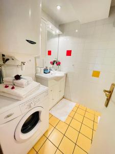 uma casa de banho com uma máquina de lavar roupa e um lavatório em Le Jardin croix Roussien em Lyon