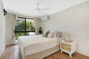 巴迪纳Beachfront Styled 2 BR Apt w Pool at Buddina的一间带大床和窗户的白色卧室