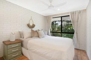 巴迪纳Beachfront Styled 2 BR Apt w Pool at Buddina的一间带大床和窗户的白色卧室