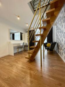 a living room with a wooden staircase in a house at Apartamenty Centrum Apartament X1 in Mszana Dolna