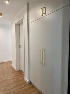 a room with white cabinets and a hallway with wood floors at Apartamenty Centrum Apartament X1 in Mszana Dolna