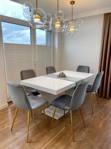 a dining room with a white table and chairs at Apartamenty Centrum Apartament X1 in Mszana Dolna