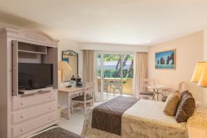 a hotel room with a bed and a television at Posada Real Los Cabos in San Jos&eacute; del Cabo