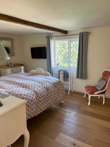 a bedroom with a bed and a chair and a window at Cosy Flint Cottage in Eastbourne