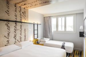 een hotelkamer met 2 bedden en een raam bij ibis Styles Meaux Centre in Meaux