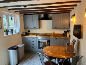a kitchen with a wooden table and a table and chairs at Cosy Flint Cottage in Eastbourne
