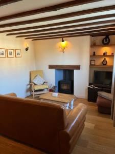a living room with a couch and a fireplace at Cosy Flint Cottage in Eastbourne