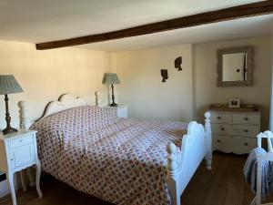 a bedroom with a white bed and two night stands at Cosy Flint Cottage in Eastbourne