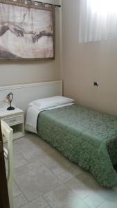 1 dormitorio con 1 cama y 1 mesa con lámpara en B&B Manzoni Resort, en Brindisi