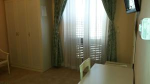 a room with a table and a window with curtains at B&B Manzoni Resort in Brindisi