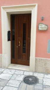 a brown door of a pink building with a manhole at B&B Manzoni Resort in Brindisi