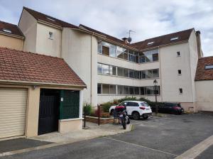 a motorcycle parked in a parking lot in front of a building at Duplex Autonome Cosy à Paris Roissy CDG in Roissy-en-France