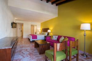 a hotel room with a couch and a bed at Canto del Sol Puerto Vallarta All Inclusive in Puerto Vallarta