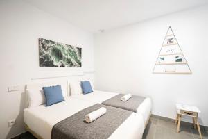 a white bedroom with a bed and a christmas tree at dobohomes - Horcajuelo in Madrid