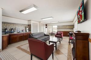 a lobby with a couch and chairs and a bar at Red Roof Inn College Station in College Station