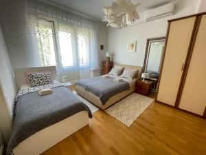 Un dormitorio con dos camas y un espejo. en Hestia Apartment, en Zagreb