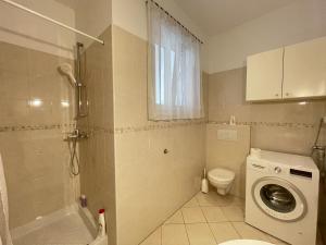 Un baño con lavadora y un inodoro. en Hestia Apartment, en Zagreb 5 fotos más